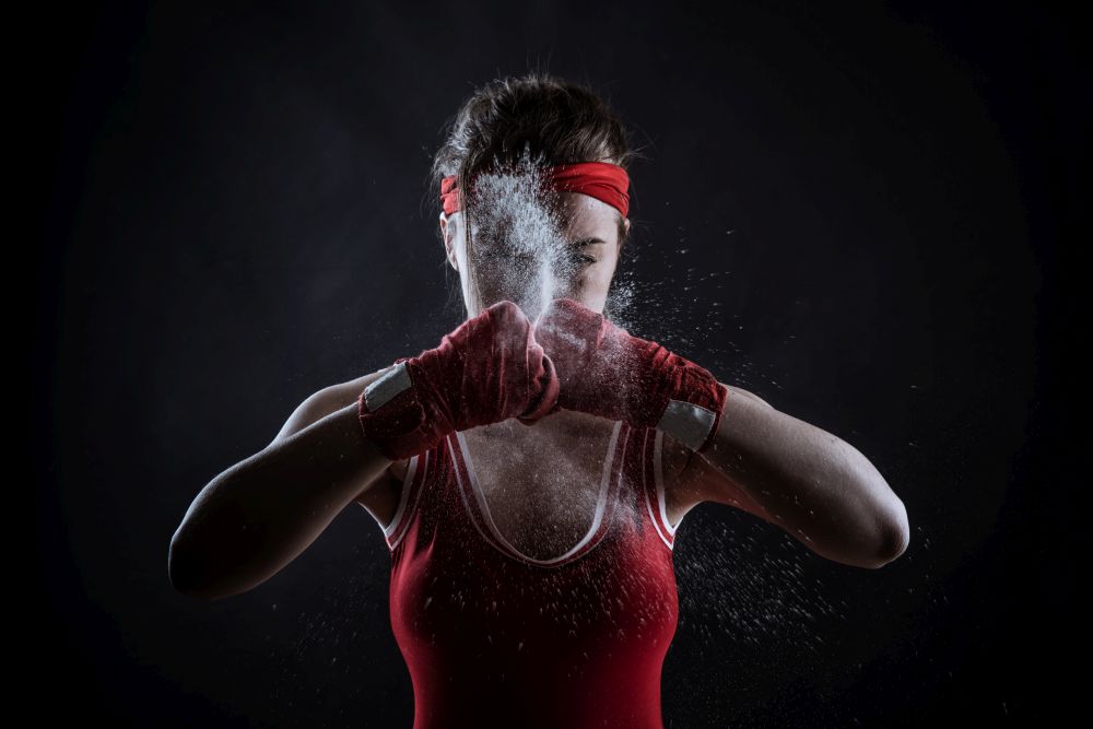 Female athlete in red boxing bandages and sportswear, front view. Fighting sport concept
