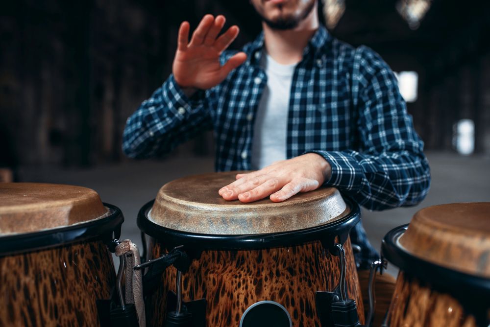 Drummer hands playing on wooden drum, closeup. Bongo, musical percussion instrument, ethnic music