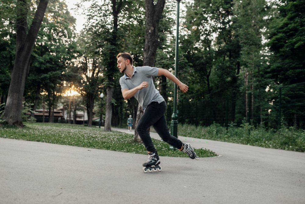 Roller skating, male skater rolling in action. Urban roller-skating, active extreme sport outdoors, youth leisure, rollerskating. Roller skating, male skater rolling in action