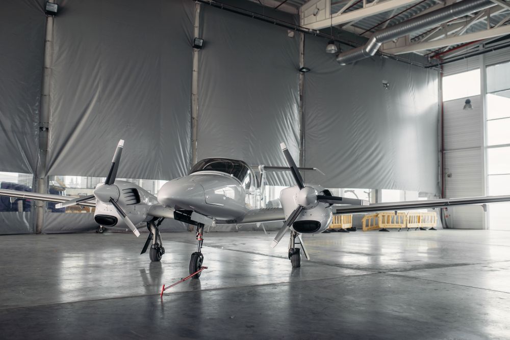 Private turbo-propeller airplane in hangar, plane on inspection before flight.Business air transportation on turboprop plane. Private turbo-propeller airplane in hangar, nobody