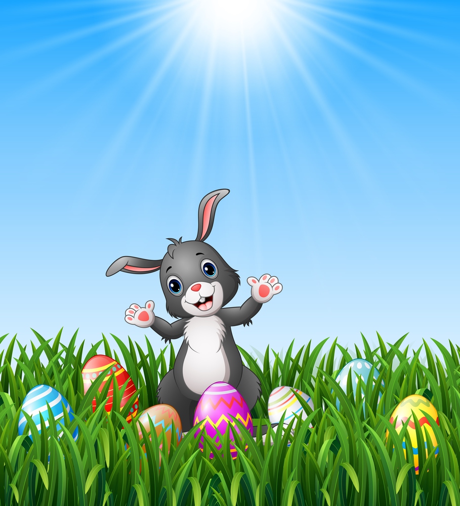 Easter bunny cartoon with Easter eggs in the grass on a background of bright sunshine