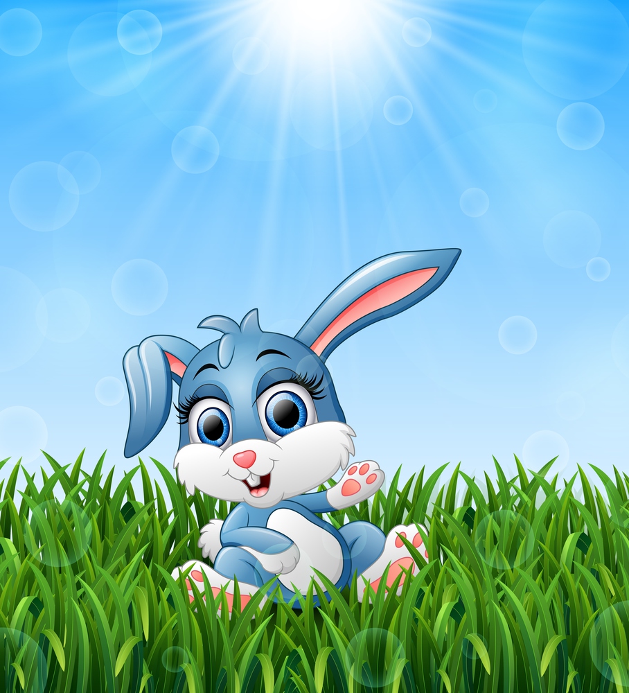 Cartoon rabbit sitting in the grass on a background of bright sunshine