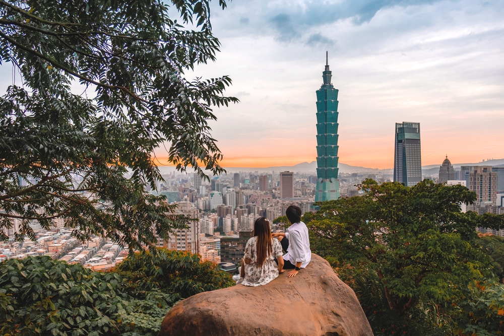 Traveler couple and sunset with view of skyline of Taipei cityscape Taipei 101 building of Taipei financial city ,Taiwan stock