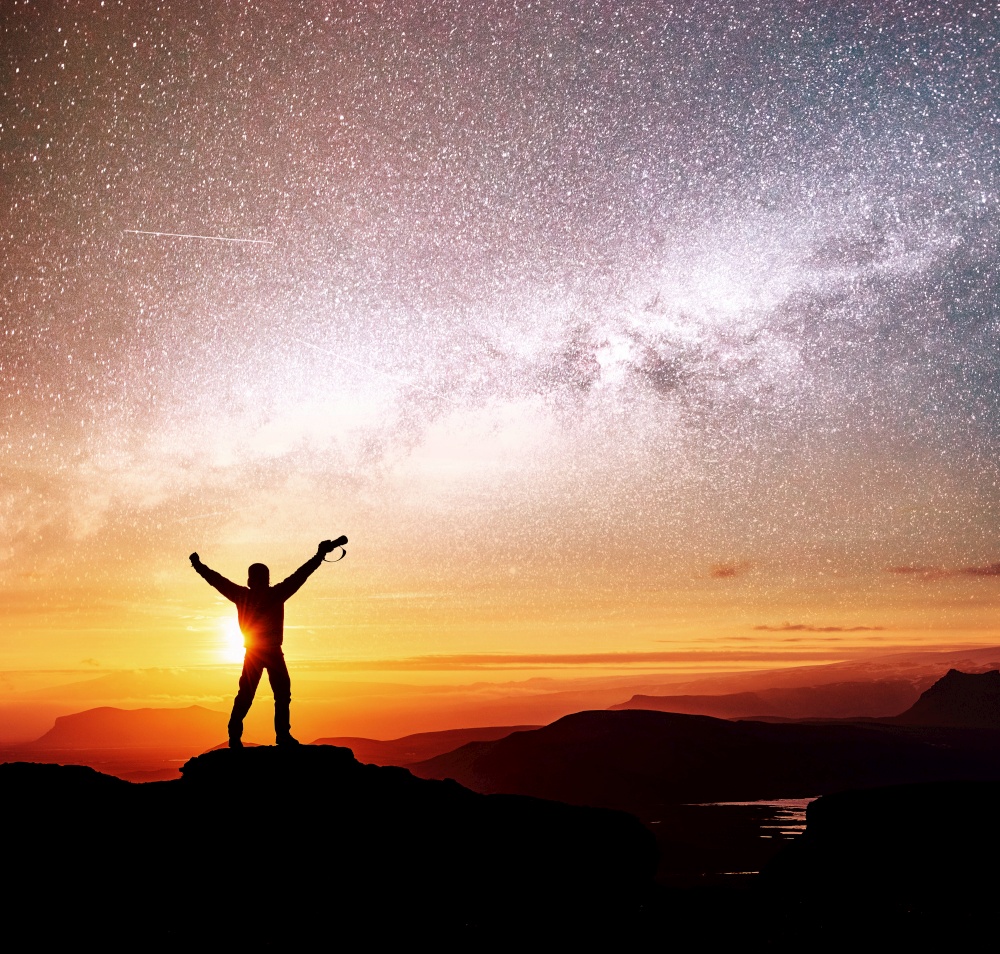 Silhouette of woman is standing on top of mountain and pointing to The milky way before sunrise and enjoying with colorful night sky.. Silhouette of woman is standing on top of mountain and pointing to The milky way before sunrise and enjoying with colorful night sky