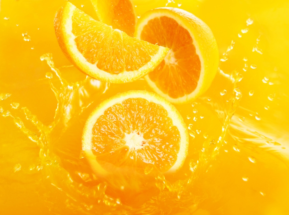 Fresh oranges falling in juice with lot of huge splashes. Fresh oranges falling in juice