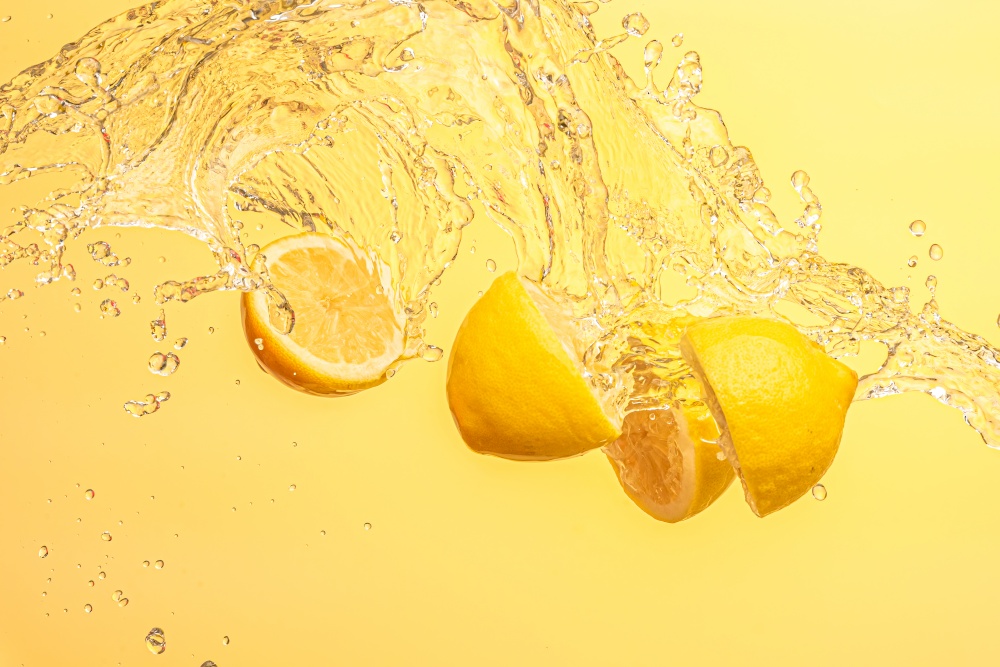 Lemon halves splashing in mid air against yellow background. Splash photography background. Lemon halves splashing in mid air against yellow background