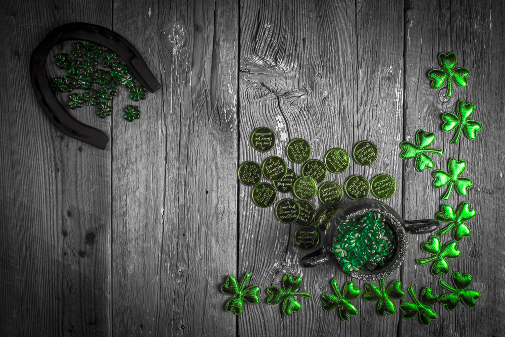 St. Patricks Day composition. Shamrocks, horseshoe, coins and silver pot on vintage style wood background. St.Patrick&rsquo;s day holiday symbol. Top view, copy space.