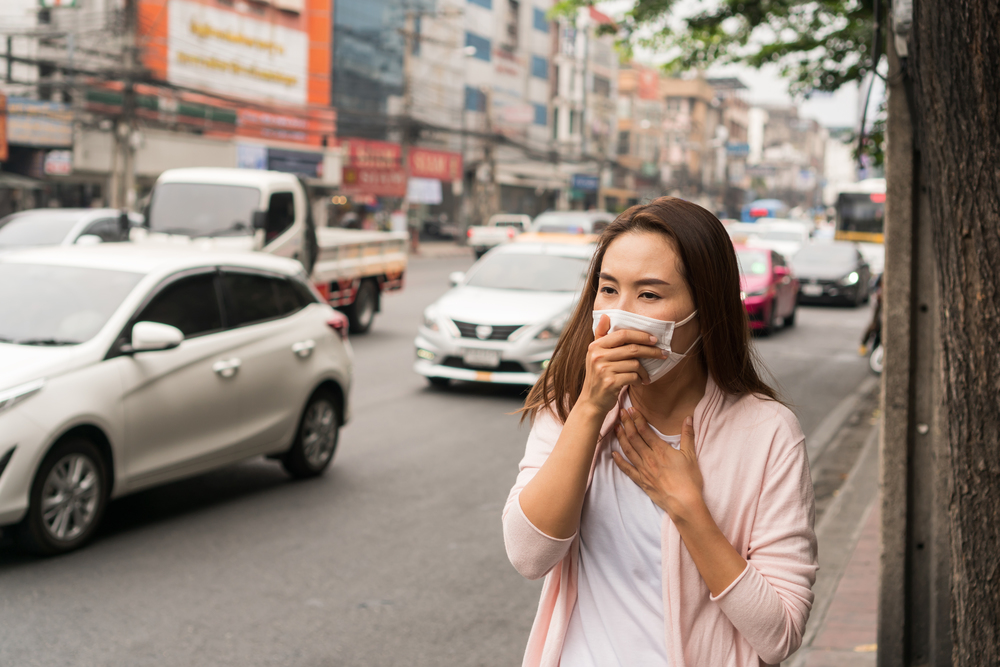 Portrait of young Asian girl wearing a mask in the city street. Prevent pollution and disease concept.