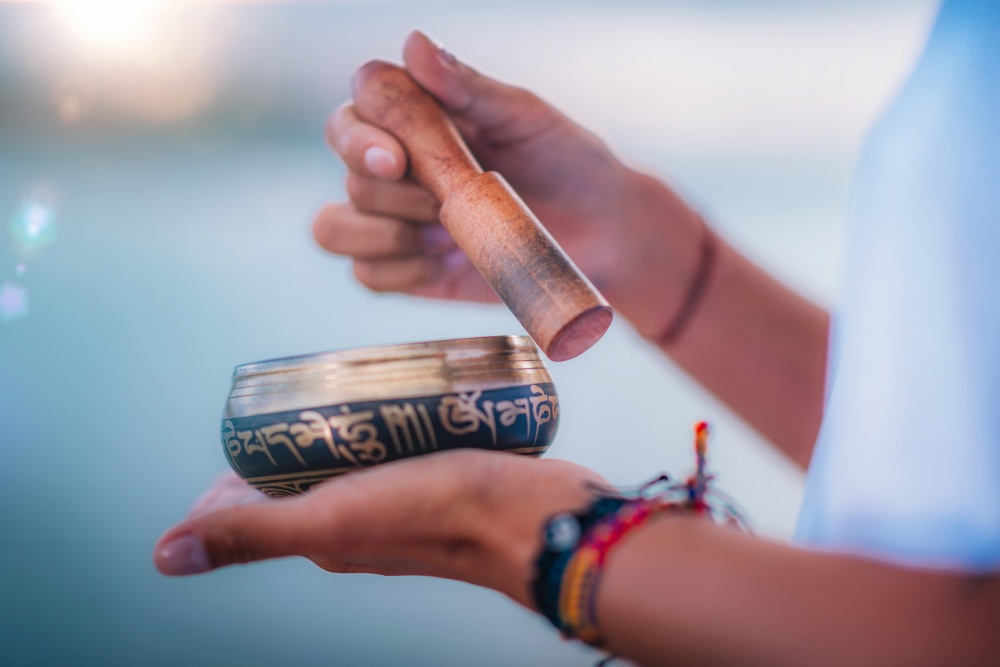 Close up image of woman&rsquo;s hands holding Tibetan Singing Bowl Outdoors