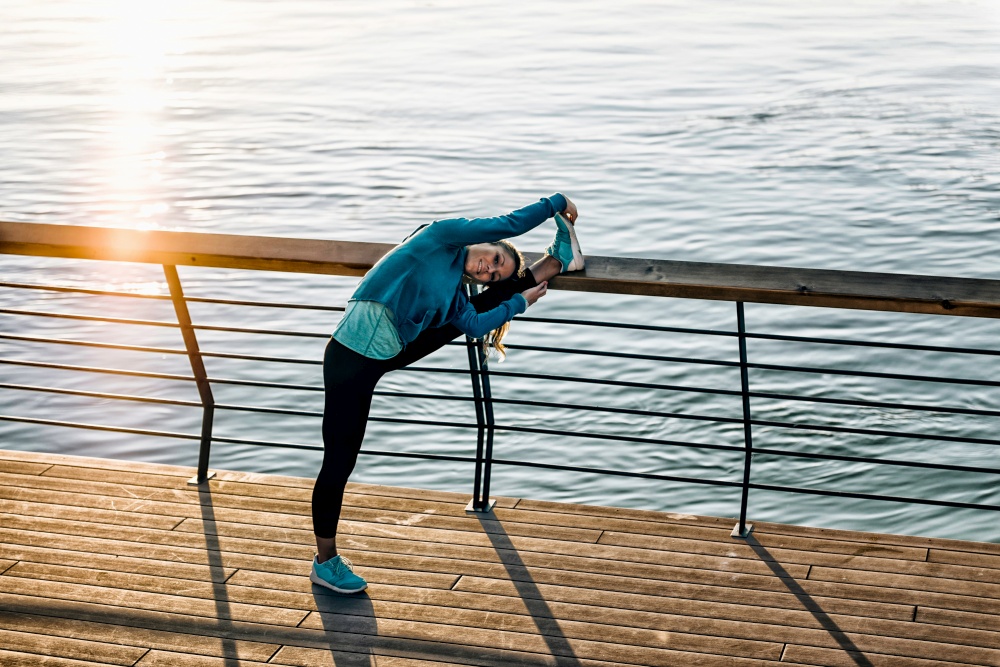 Woman stretching after training outdoors during sunset