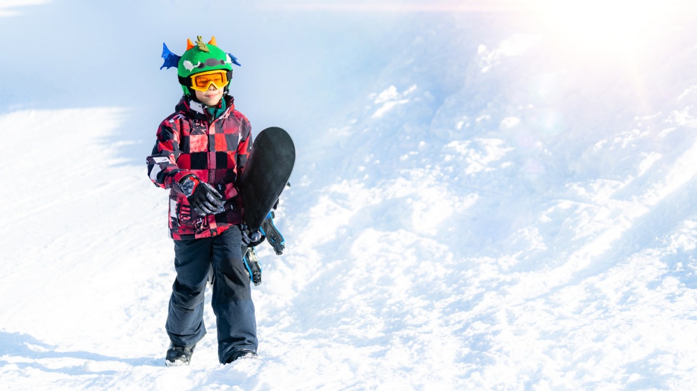 Boy with Snowboard in the Mountain Winter Resort