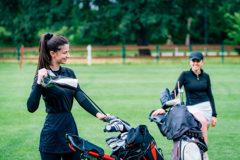 Two young ladies playing golf, having fun
