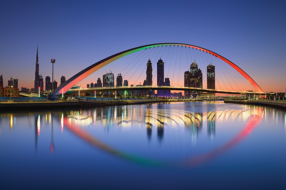 Dubai water canal at sun rise and colorful bridge as viewed Dubai, United Arab Emirates on November 2017