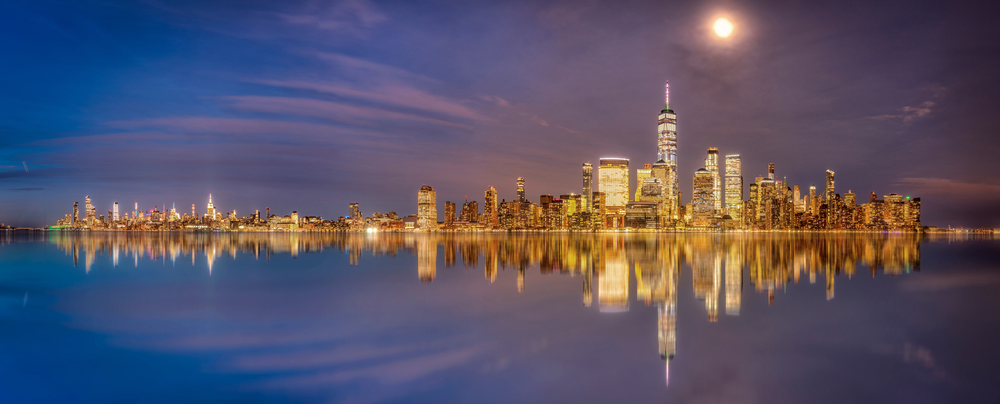 New York and New Jersey skyline from new jersey deck at sunset blue hour with reflection on hudson river