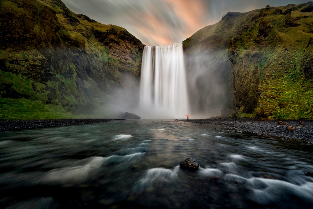 Waterfall and water flowing through iceland in skogafoss, Iceland at sunset