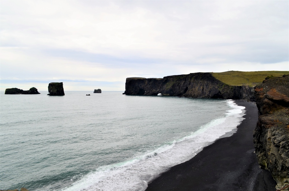 Near Dyrholaey in southern Iceland, black sand and beach, cold icy water