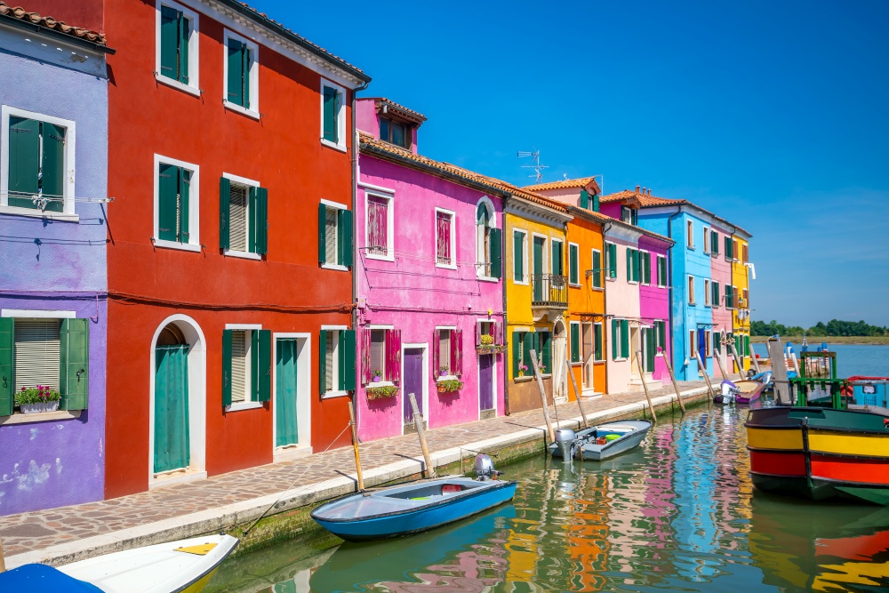 Colorful houses in downtown Burano, Venice, Italy with clear blue sky