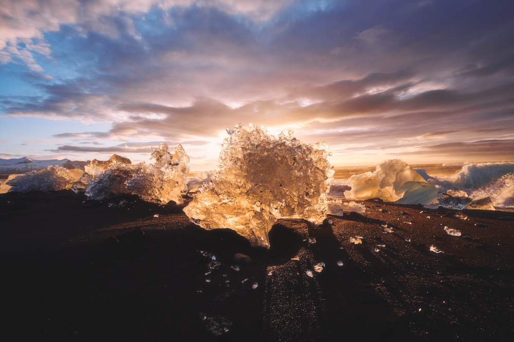 Sunrise at Diamond beach with ices from Jokulsarlon glacier lagoon get washed ashore and strand on the black beach, Iceland