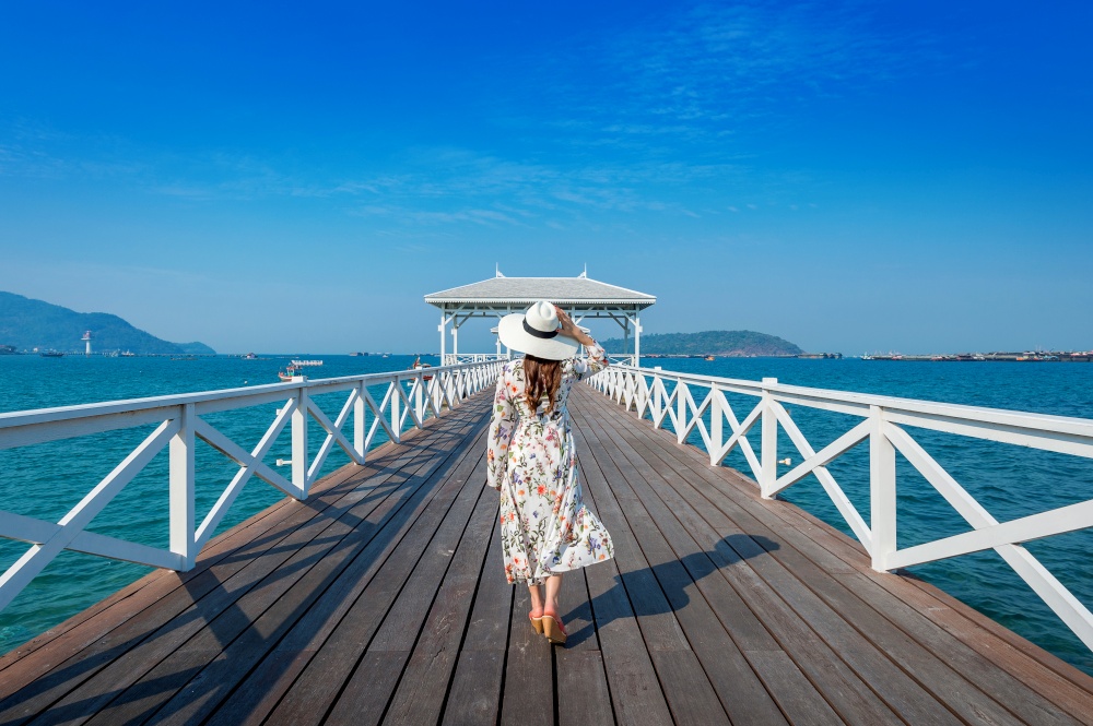 Young woman walking on wooden bridge in Si chang island, Thailand.