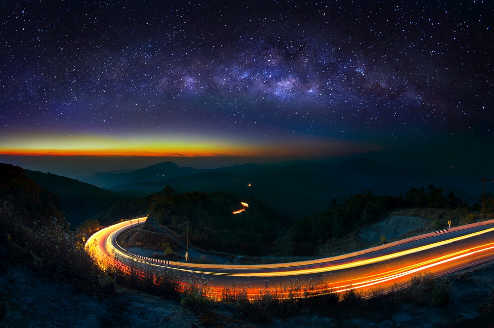 Milky way and car light on road at Doi Inthanon National park in the night, Chiang Mai, Thailand.