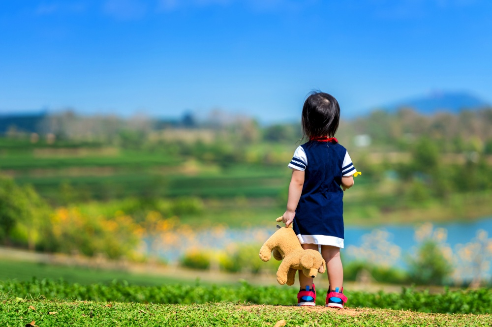 A girl standing on green grass.
