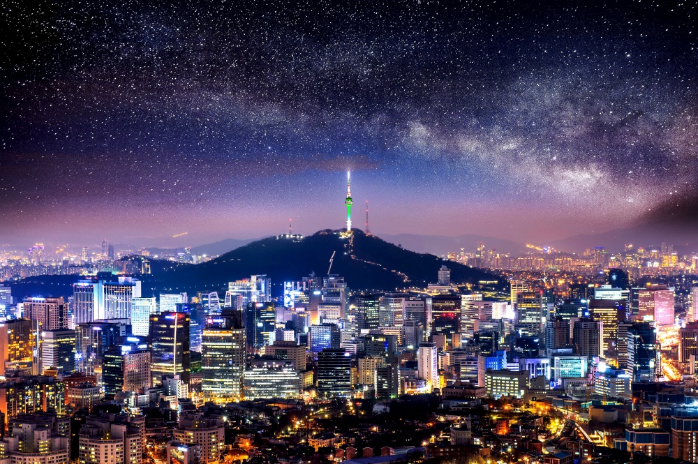 View of downtown cityscape and Seoul tower with Milky way in Seoul, South Korea.