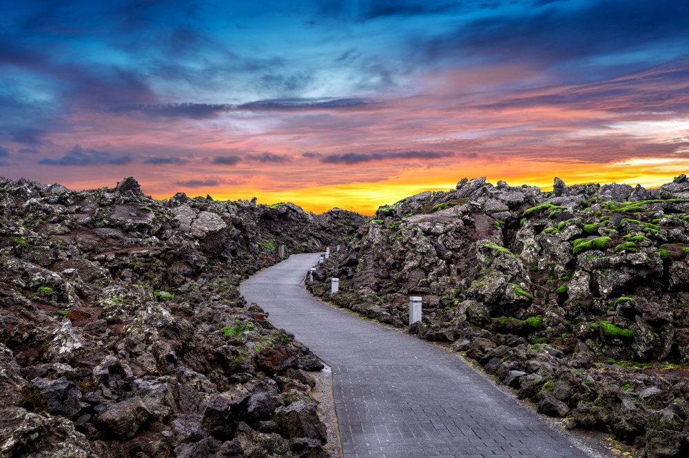 Blue lagoon entrance with Lava rocks and green moss at sunset in Iceland.