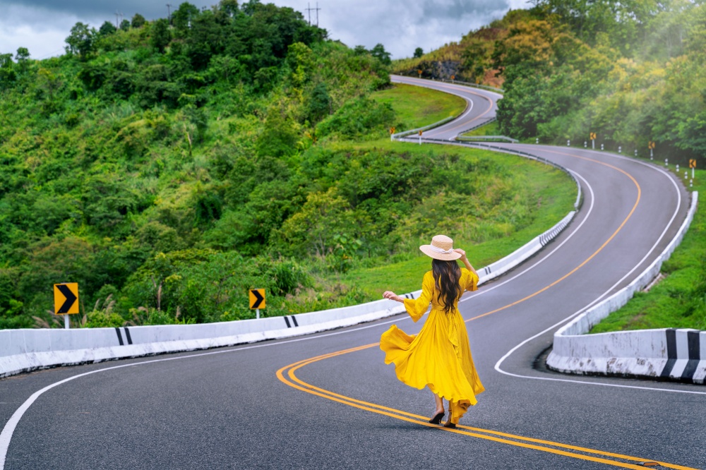 Woman walking on road no.3 or sky road over top of mountains with green jungle in Nan province, Thailand.