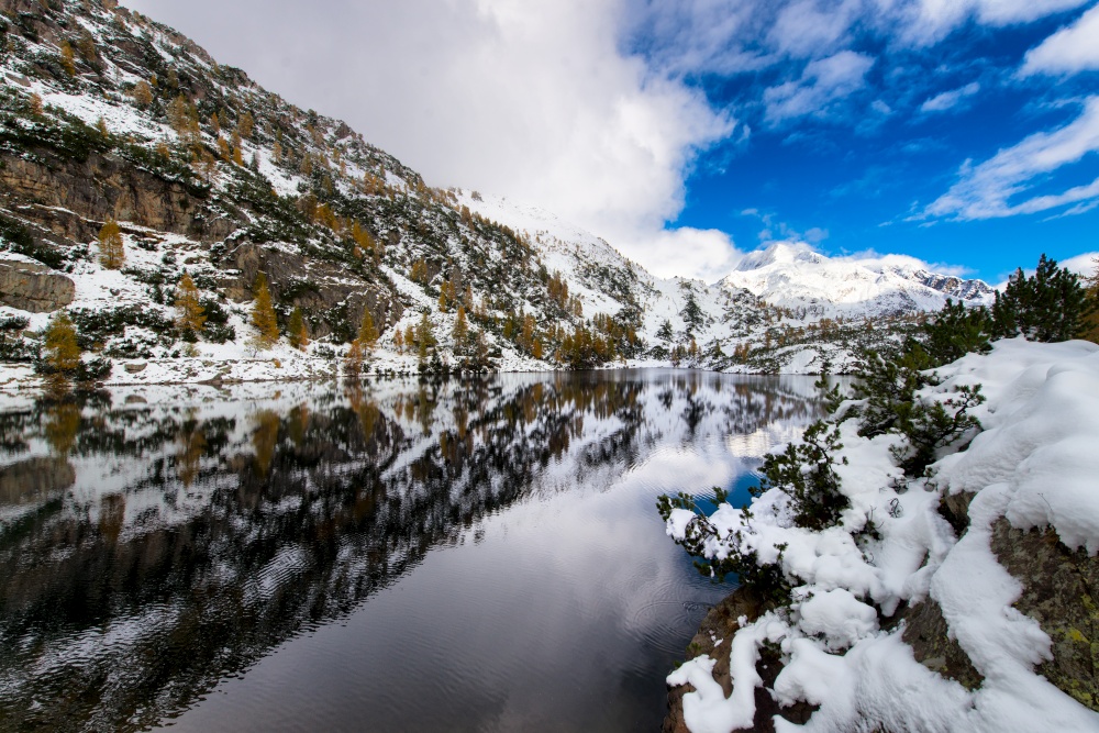 Mountains and alpine lake with first snow fall