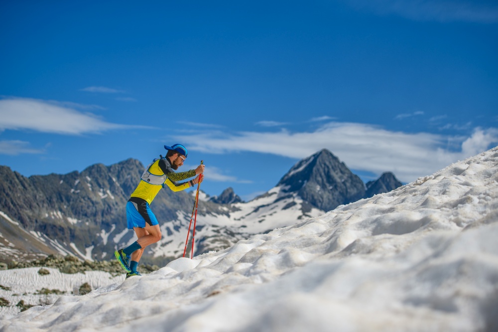 Skyrunning training with sticks on the snow uphill