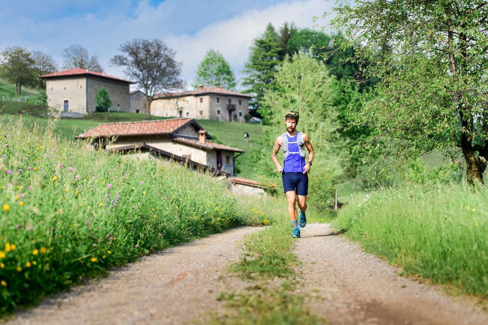 Young athlete runs in rural hill landscape