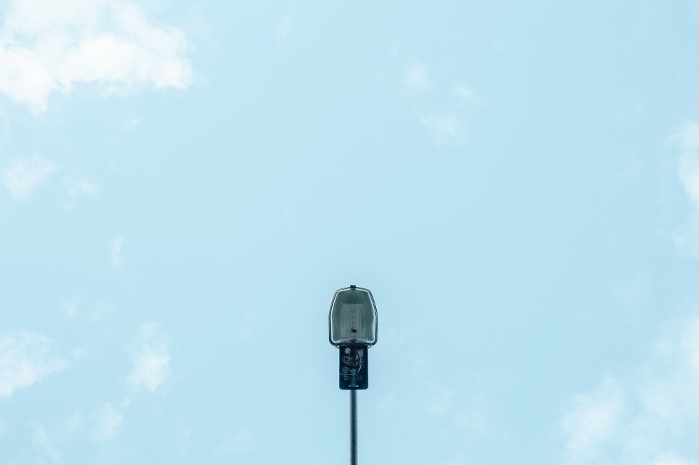 A minimalistic shot of a single street lamp with the sky as the background