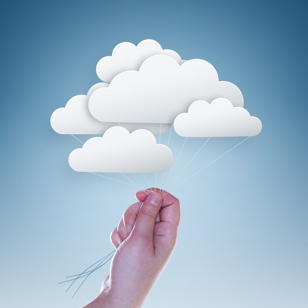 hand holding clouds on light blue background