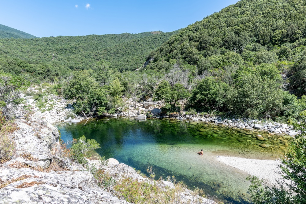 Adult woman in a Pure and fresh water natural pool of Travu River, Corsica, France, Europe. Pure and fresh water flowing of Travo River, Corsica, France