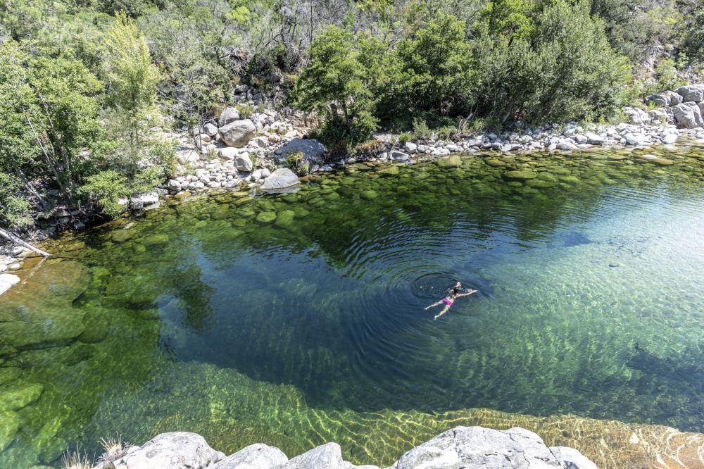 Adult woman swimming in a Pure and fresh water natural pool of Travu River, Corsica, France, Europe. Pure and fresh water flowing of Travo River, Corsica, France