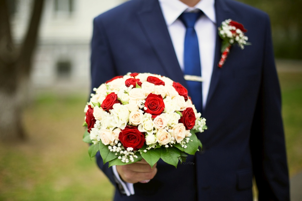 Groom with bouquet of roses