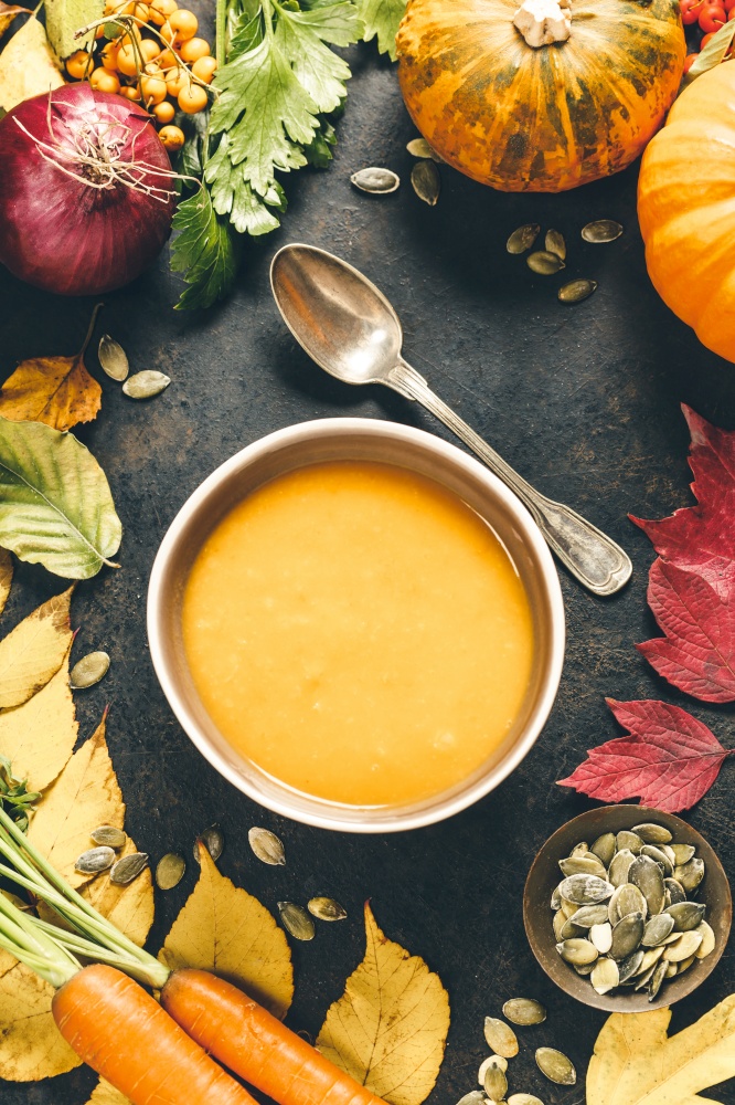 Pumpkin soup in a bowl on rustic surface. Pumpkin soup in a bowl, flat lay