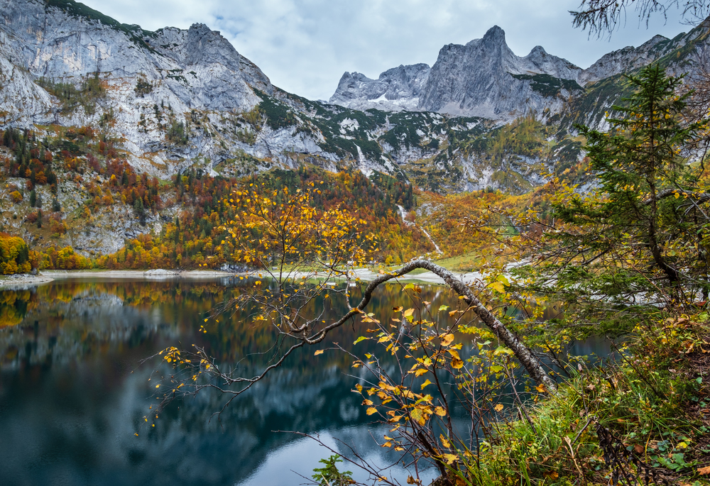 Picturesque Hinterer Gosausee lake, Upper Austria. Colorful autumn alpine view of mountain lake with clear transparent water and reflections. Dachstein summit and glacier in far.