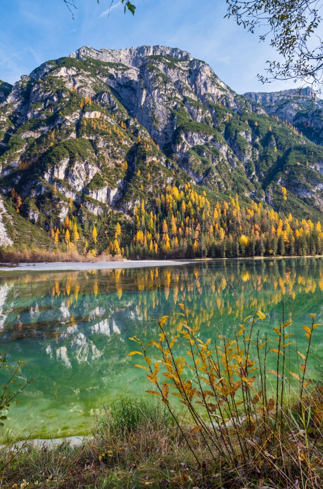 Autumn peaceful alpine lake Durrensee or Lago di Landro.  Snow-capped Cristallo rocky mountain group behind, Dolomites, Italy, Europe. Picturesque traveling, seasonal and nature beauty concept scene.