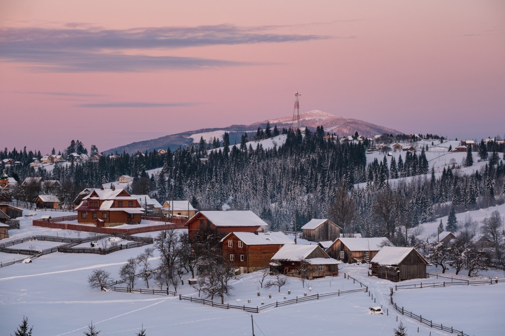 Small and quiet alpine village and winter sunrise snowy mountains around, Voronenko, Carpathian, Ukraine.