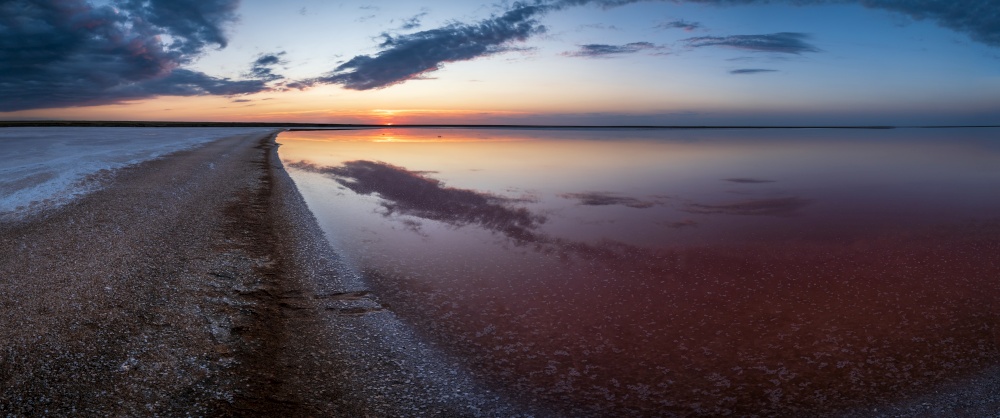 Sunset on the Genichesk pink extremely salty lake (colored by microalgae with crystalline salt depositions), Ukraine.