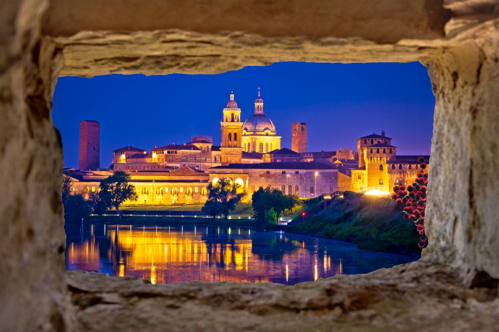 City of Mantova skyline evening view through stone window, European capital of culture and UNESCO world heritage site, Lombardy region of Italy