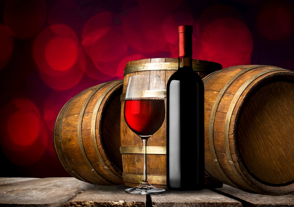 Bottle of red wine and wooden barrels