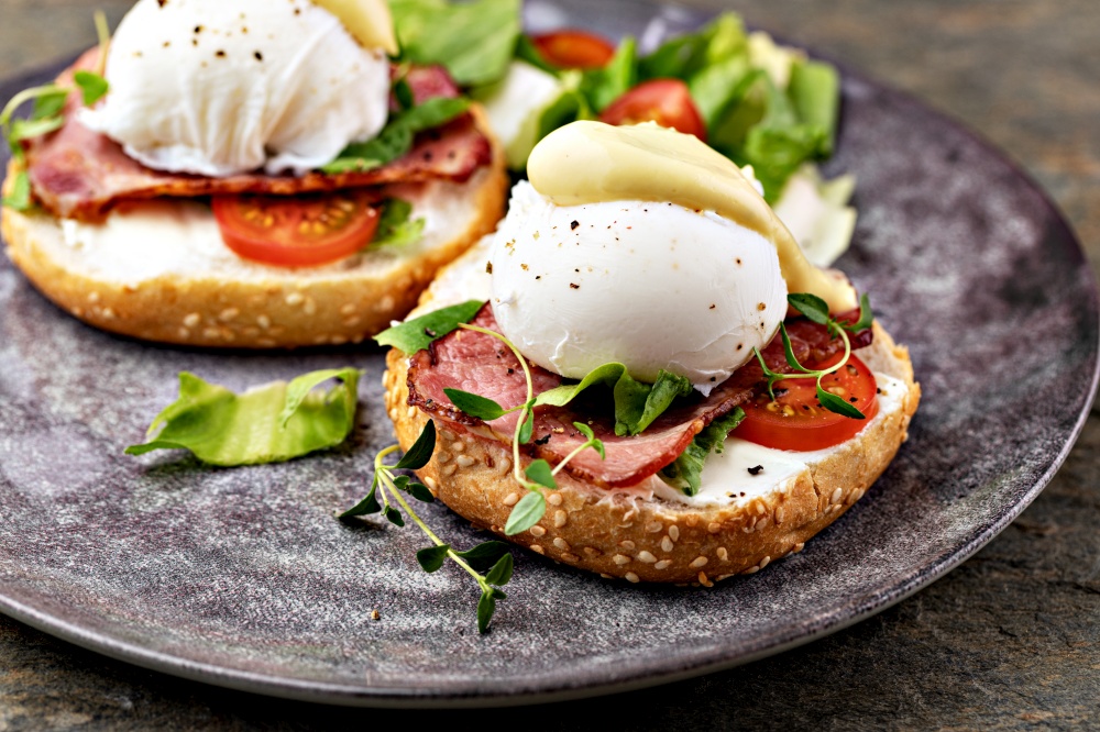Delicious breakfast with eggs Benedict and salad. Eggs Benedict with salad on the plate