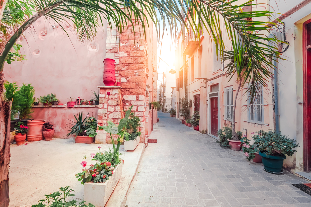 Amazing narrow streets of popular destination on Crete island. Sunny morning in Greece. Traditional architecture and colors of mediterranean city. Place for romantic vacation and summer travel